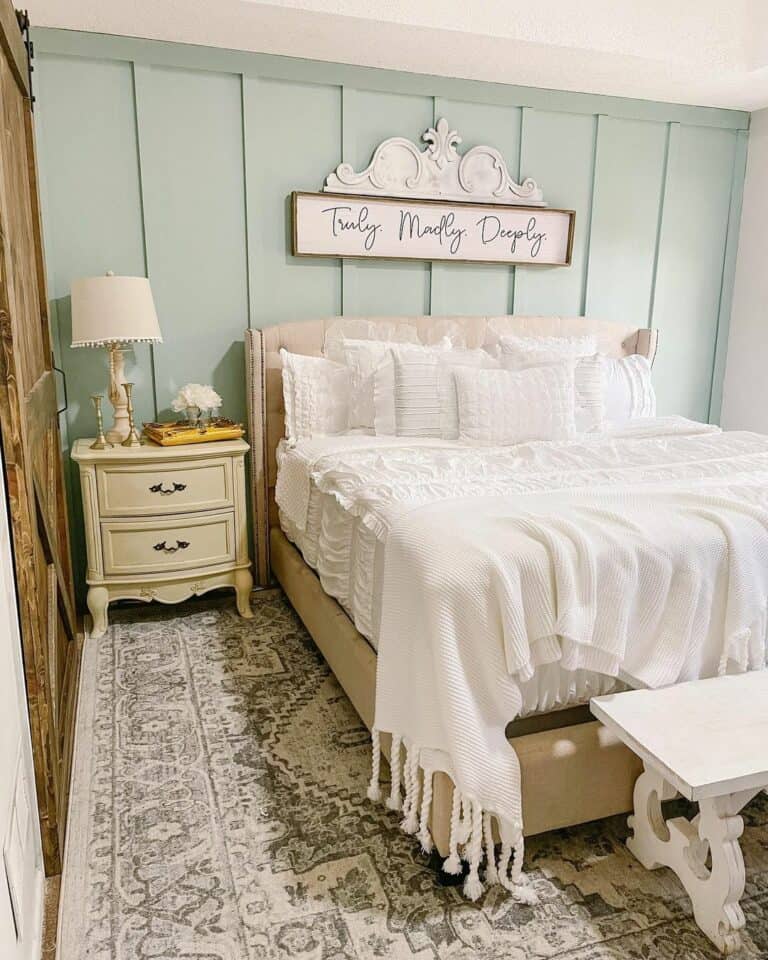 White Bench in a Bedroom With a Light Blue Paneled Bedroom Wall