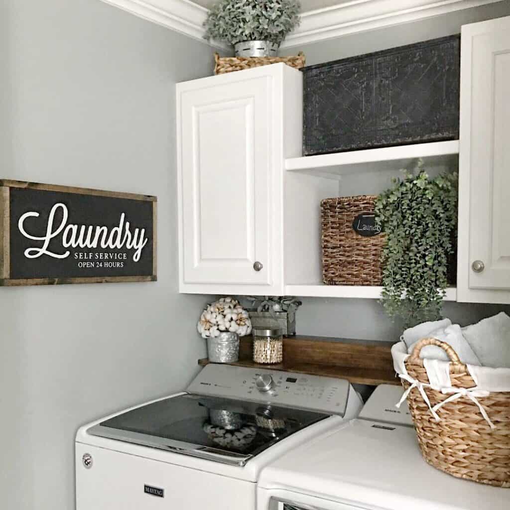 White Cabinets Next to a Black Laundry Room Sign