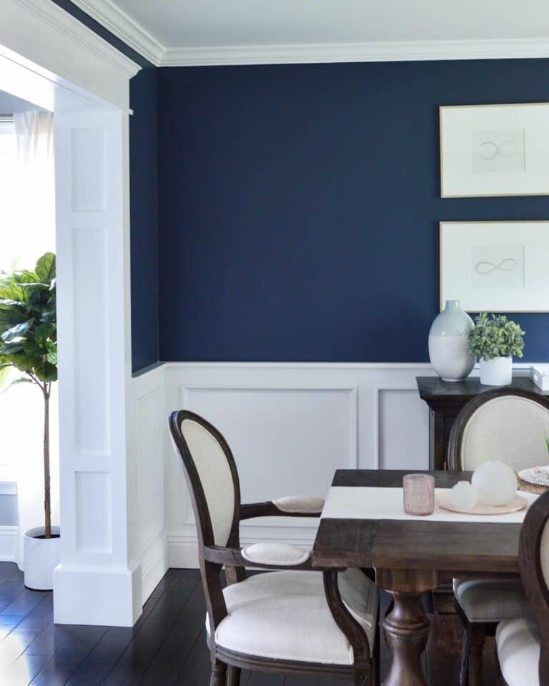 White Pictures on Dark Blue Walls With White Wainscoting