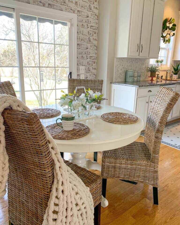 White Round Dining Table with Brick Accent Wall