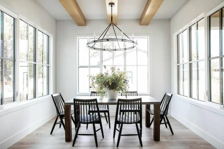 A Black Wagon Wheel Chandelier and Light Wood Beams