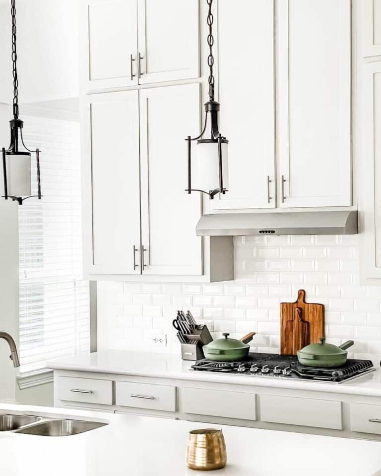 Green Pans in Front of a White Tile Kitchen Backsplash