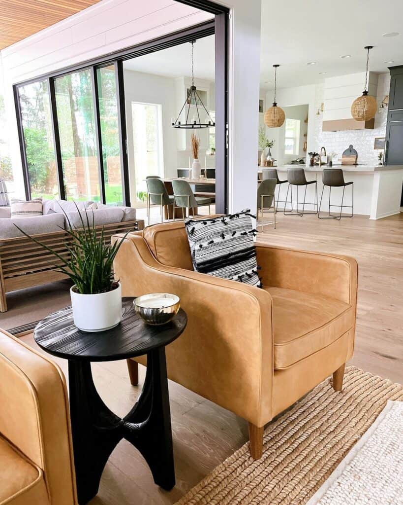 Round Black Table Between Two Brown Leather Chairs