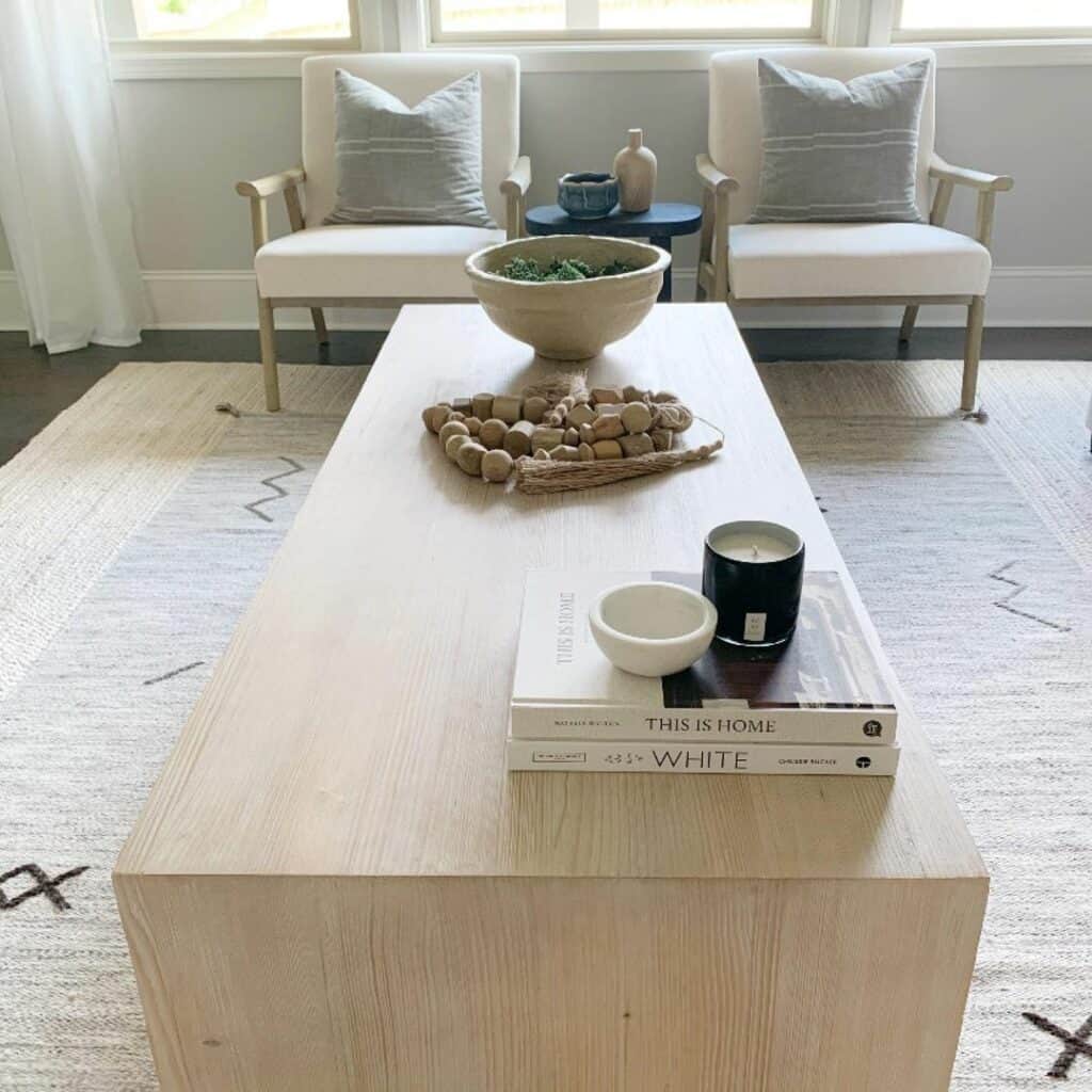 Small Black Round Table Between Two White Armchairs