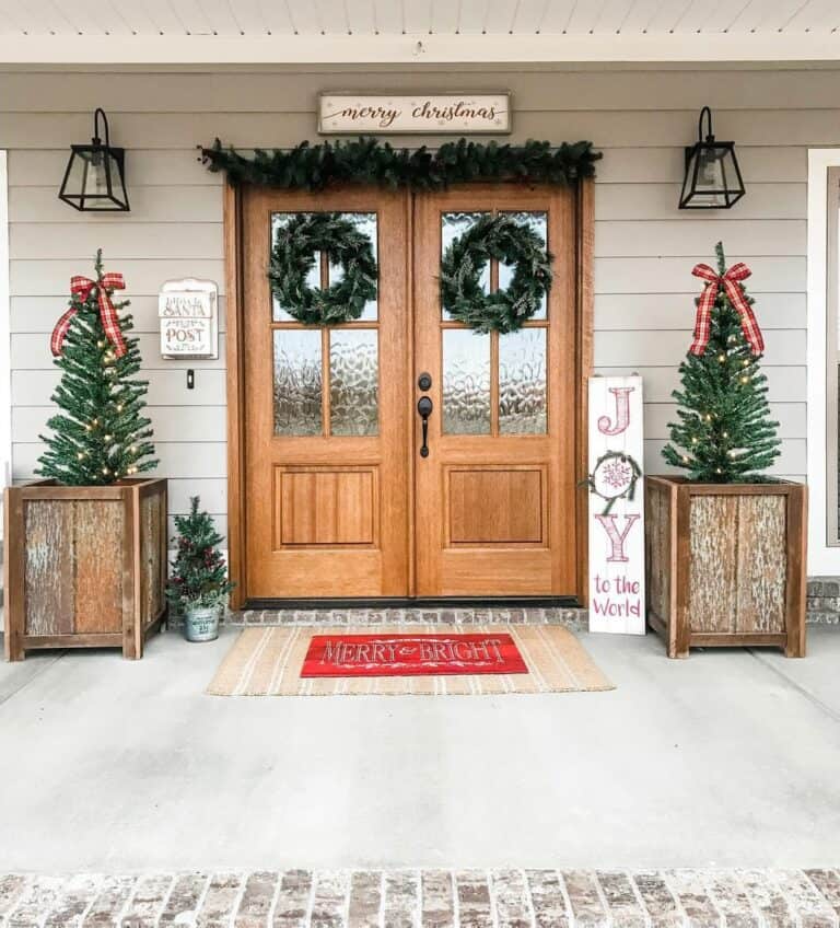 Stained Wood Double Doors With Green Wreaths