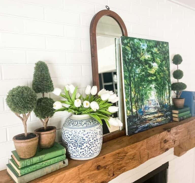 Wooden Fireplace Mantel With Miniature Topiaries and White Tulips