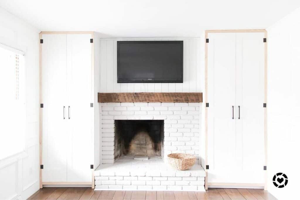 All-white Fireplace Nestled Between Cabinets