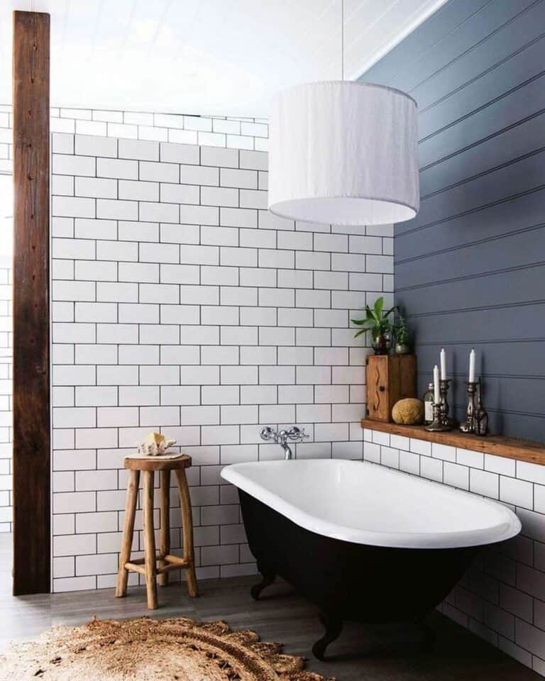 Black Clawfoot Tub Surrounded by White Subway Tile