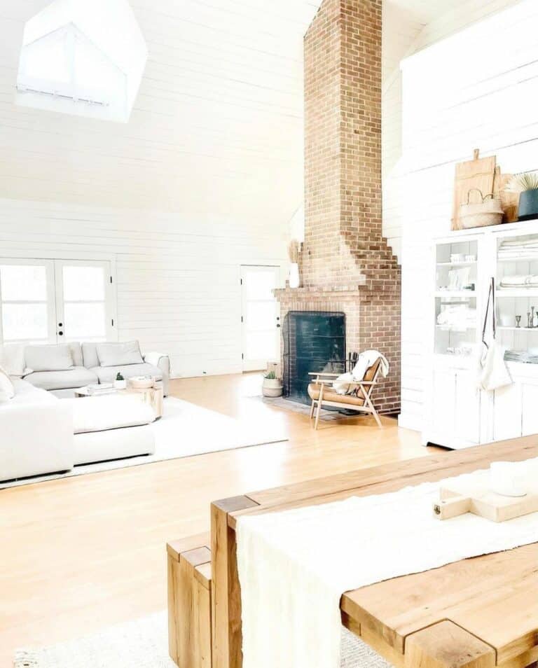 Bright Farmhouse Living Room With Brick Fireplace