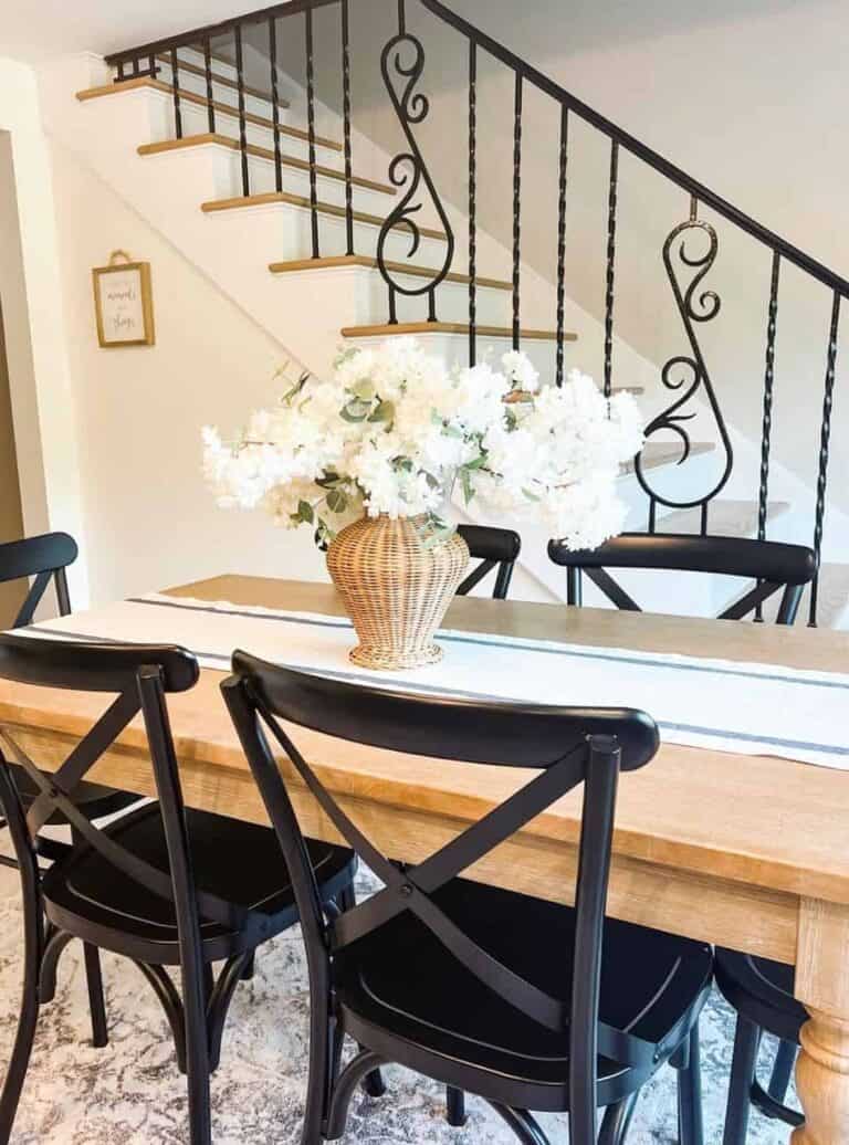Dining Table With Black Chairs and White Flowers
