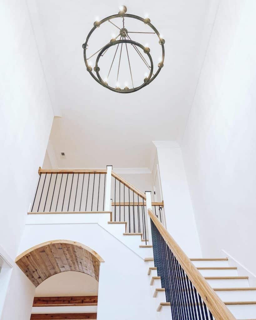 Farmhouse Staircase With Wagon Wheel Chandelier