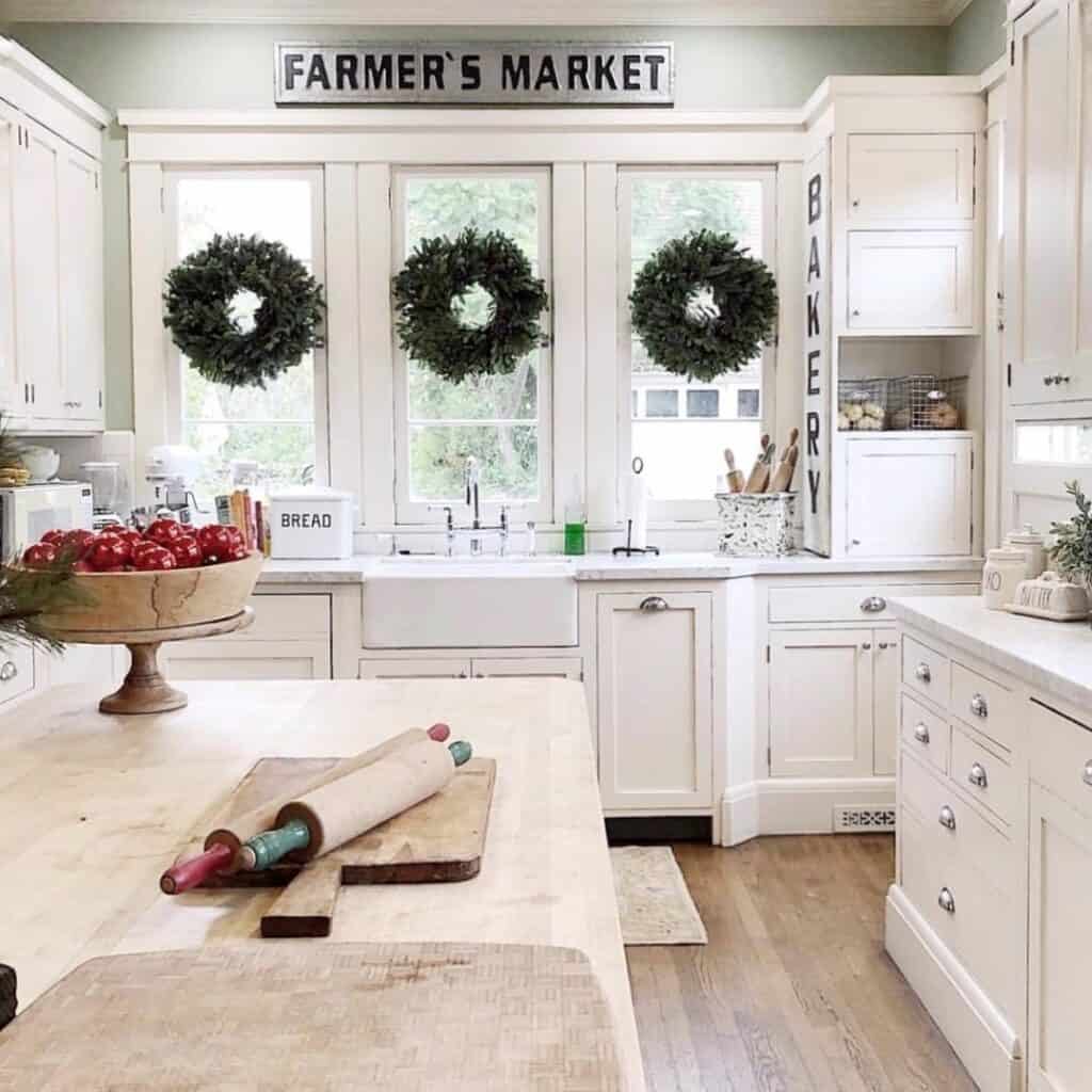Green and White Farmhouse Kitchen With Wreaths on Windows
