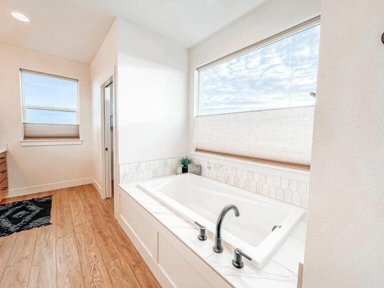 Large Recessed Tub Surrounded by White Ceramic Tile