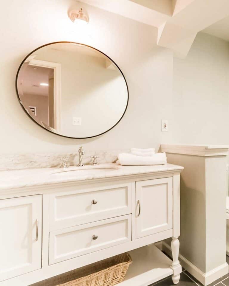 Large Round Mirror With Black Frame in Basement Bathroom