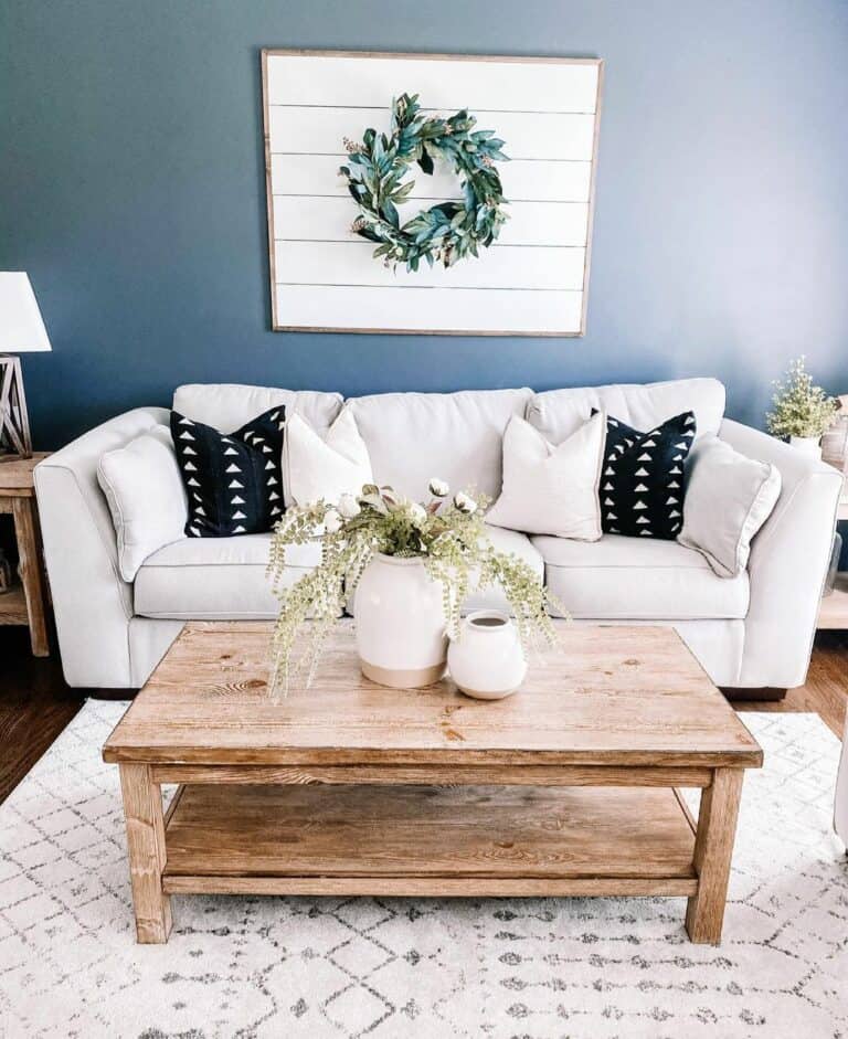 Light Wood Coffee Table With Greenery in White Vases