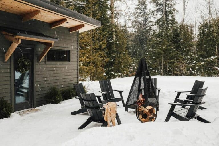 Snowy Backyard With Black Chairs Around Fire Pit