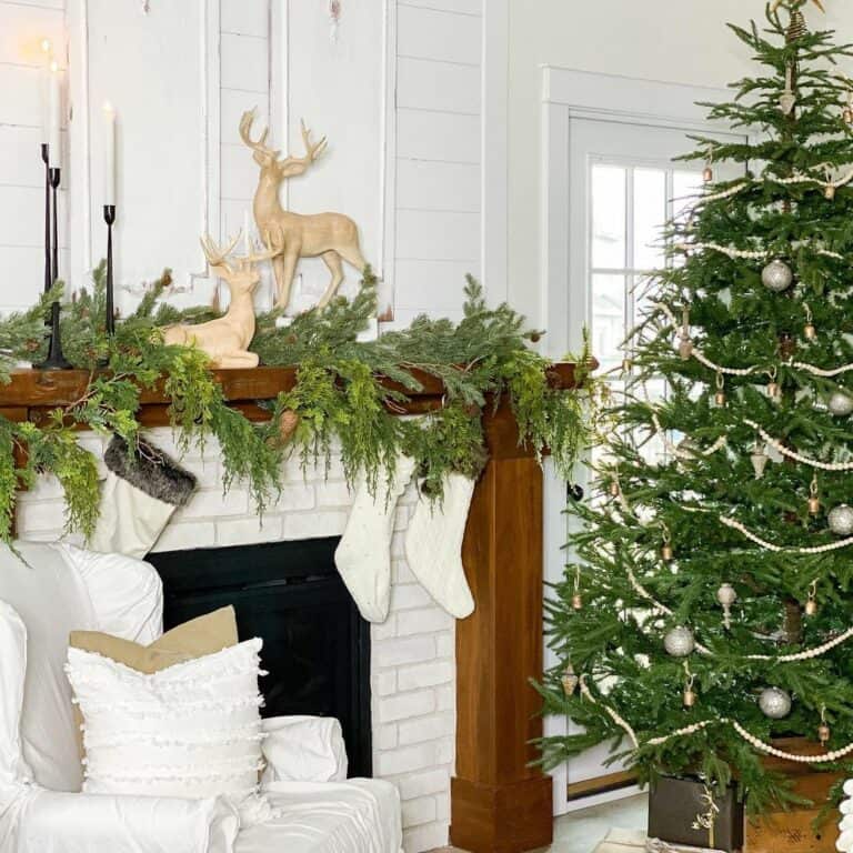 Two Reindeer and a Green Garland on a Dark Wood Mantel