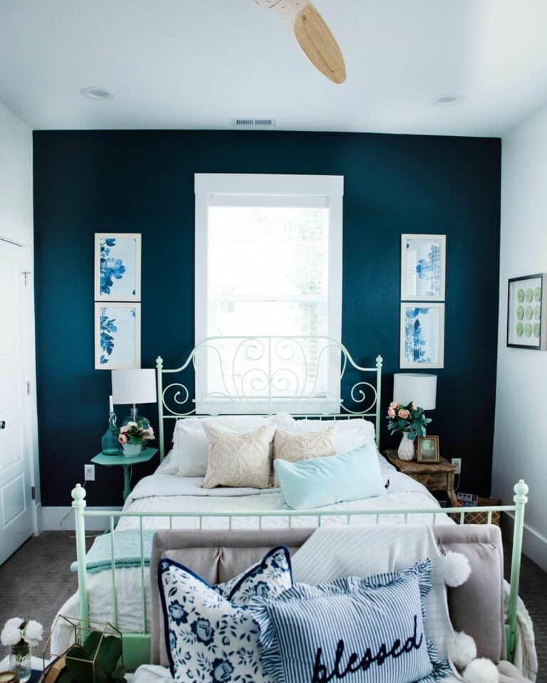 White Metal Bed Against a Dark Blue Accent Wall