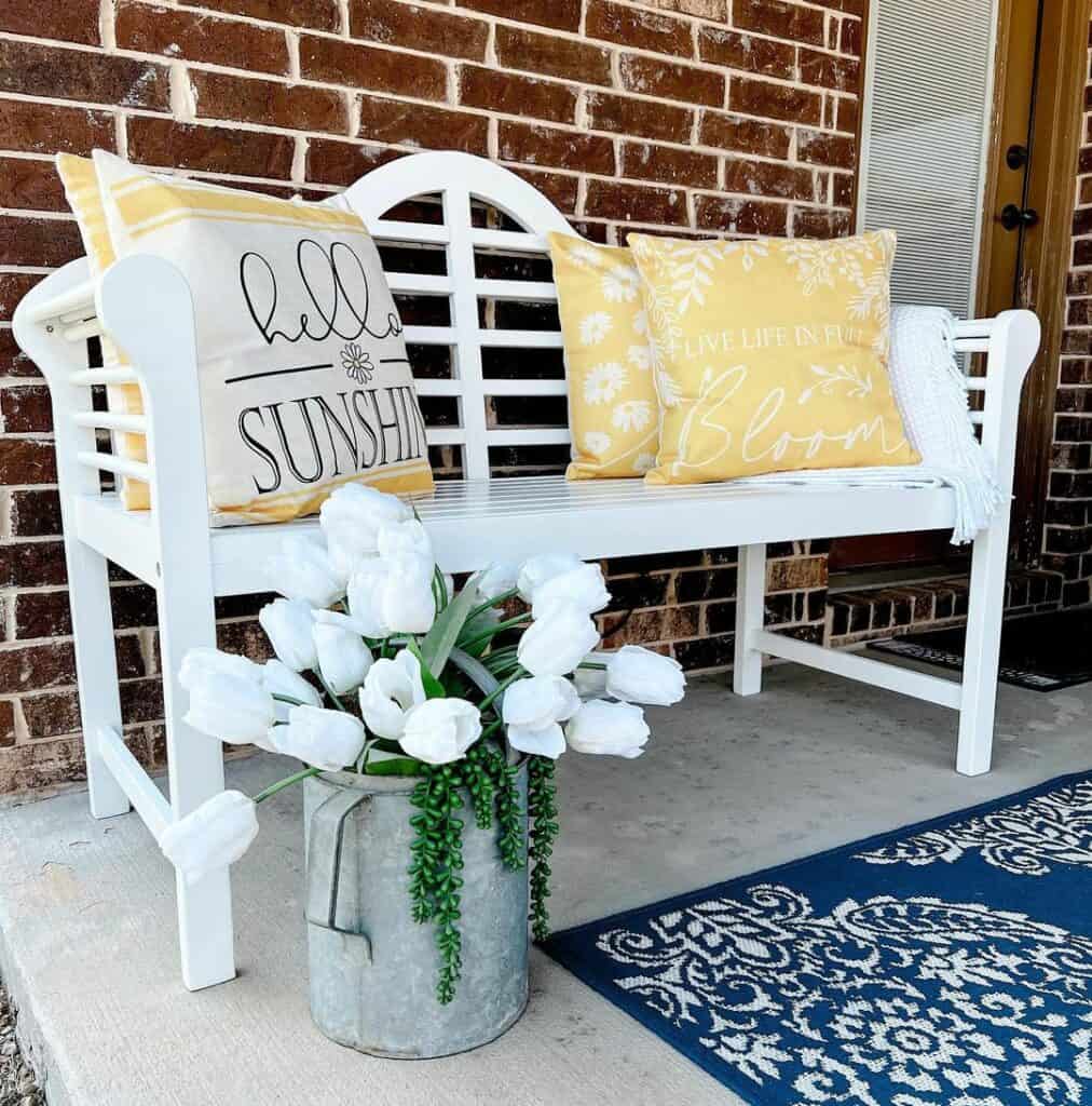 White Patio Bench With Yellow and White Pillows