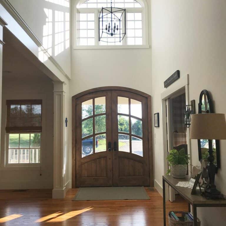 Farmhouse Foyer With Stained Wood Arched Doors