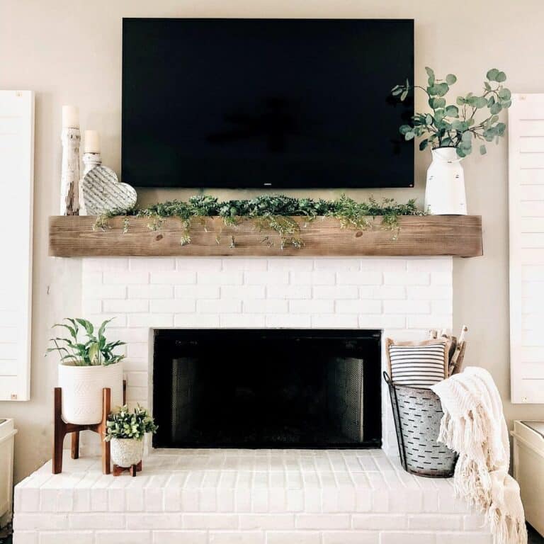Garden-inspired Painted Brick Fireplace With Greenery