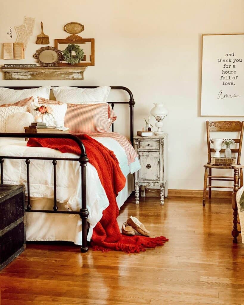 Red Blanket Draped Over Black Metal Bed
