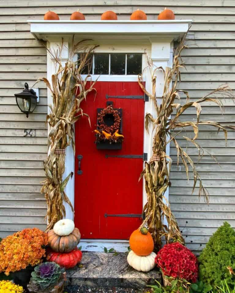 Red Farmhouse Front Door With Warm Fall Accents