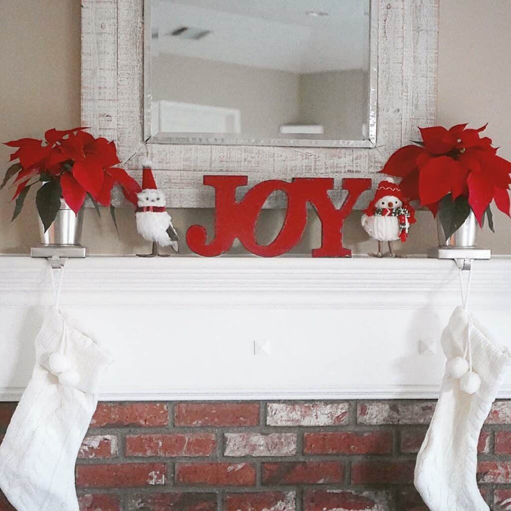 White Farmhouse Mantel With Red Decorations