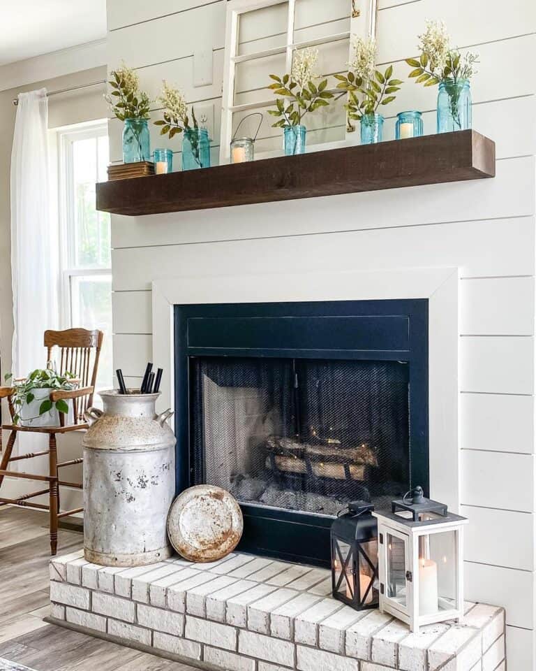 White Shiplap Fireplace With Greenery in Blue Glass Jars
