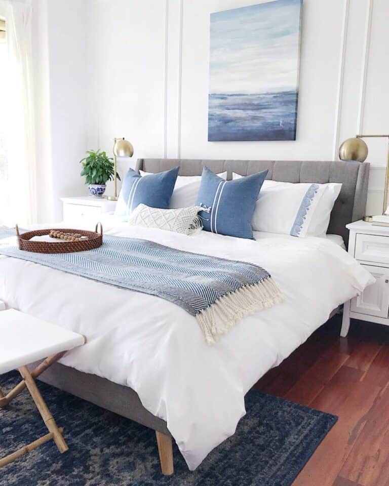 White and Blue Bedding on Grey Cushioned Bed