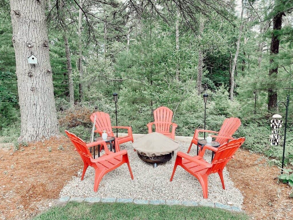 Woodsy Firepit With Red Chairs