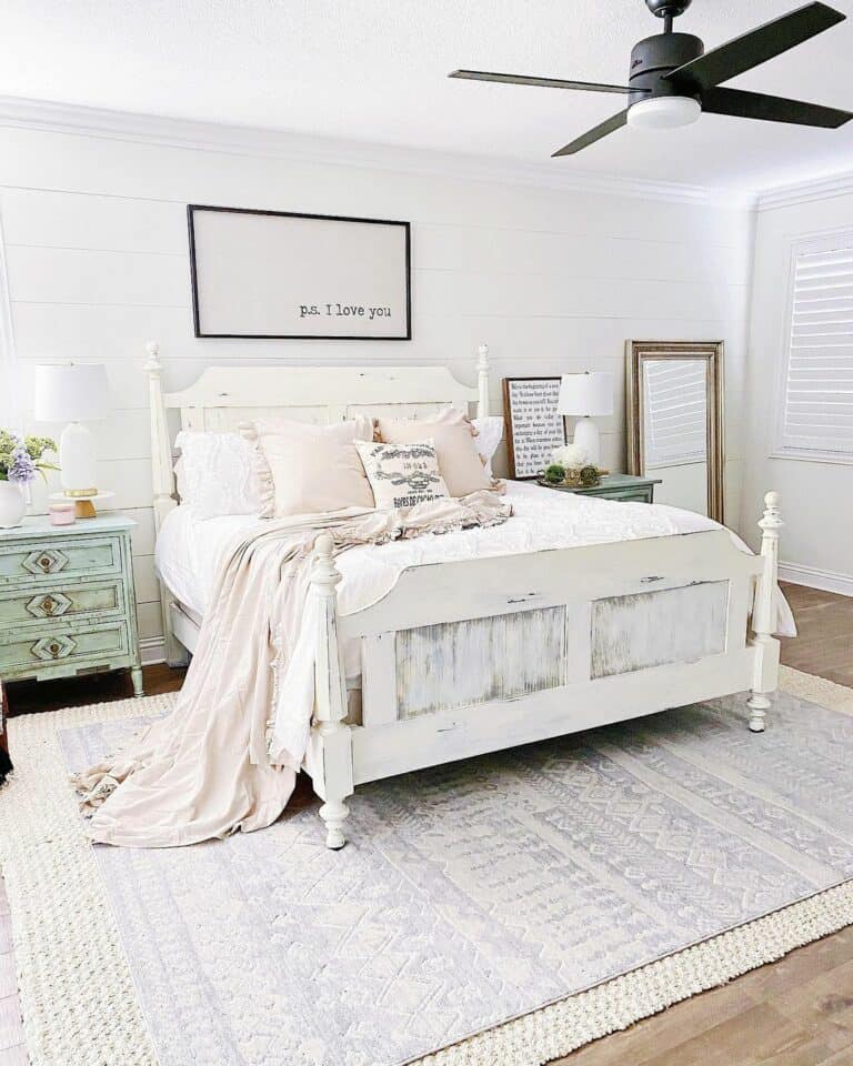 Black Frame Wall Sign Above a Rustic White Bed