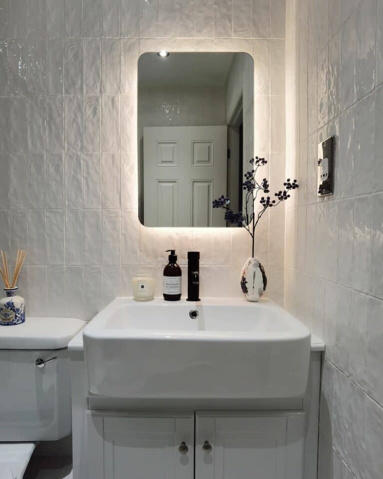 Small Bathroom With a Backlit Vanity Mirror and Textured White Tiles