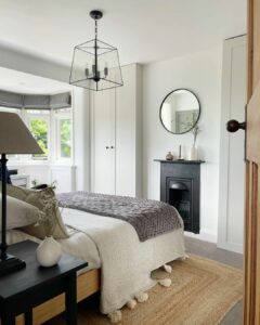 Modern Farmhouse Bedroom With a Chandelier Above the Bed