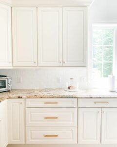 Brown Granite Countertops Under Cream Kitchen Cabinets