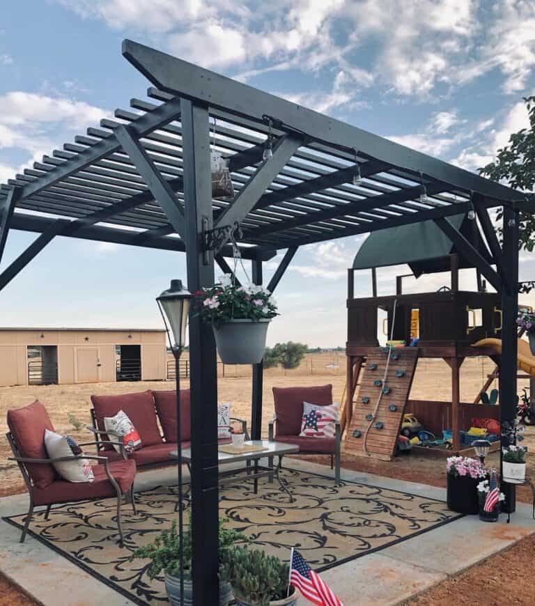 Black Pergola With Red Patio Chairs