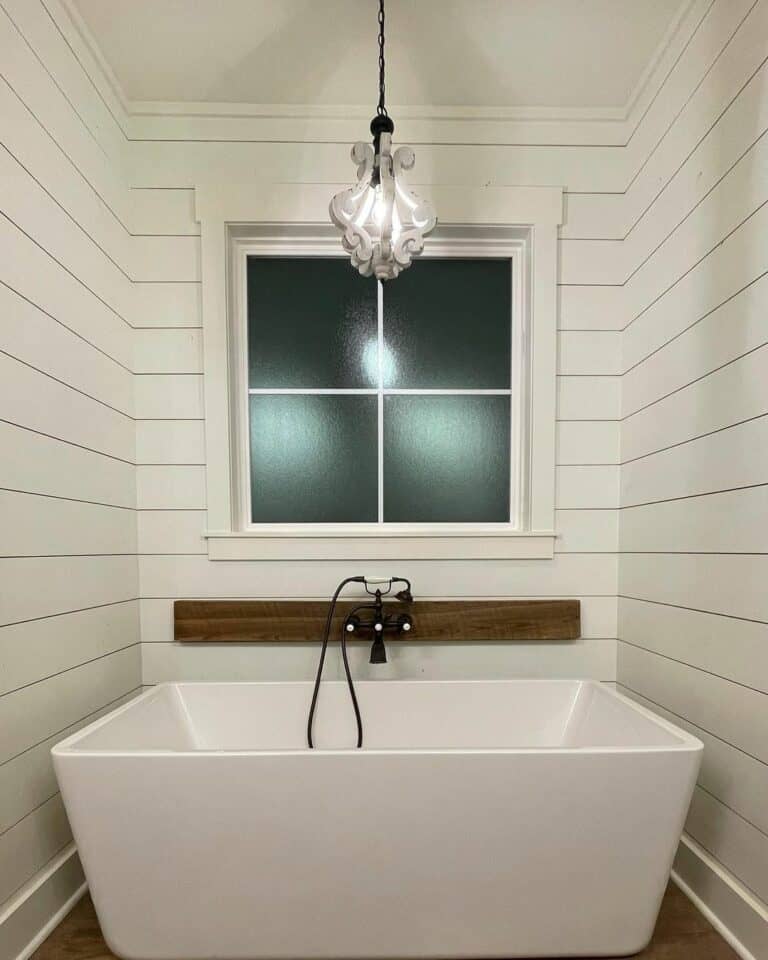 Large White Freestanding Soaking Bathtub With a Retro Faucet