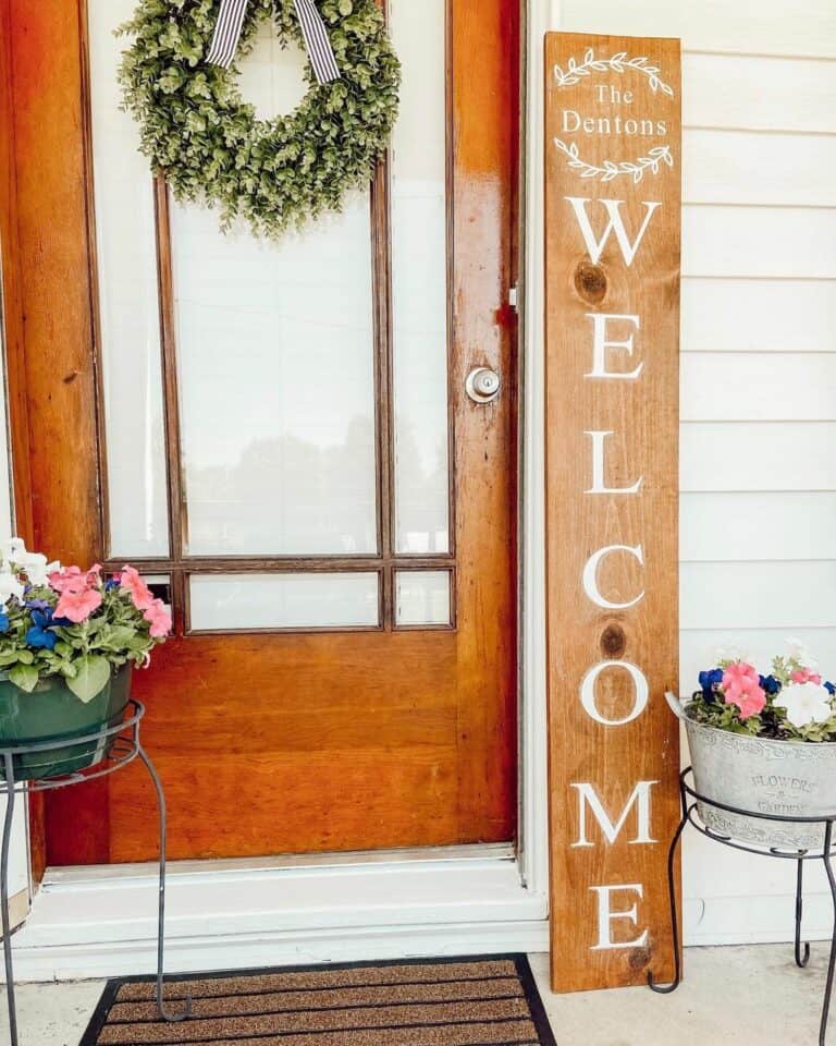 Stained Wood Front Door With Wood Welcome Sign