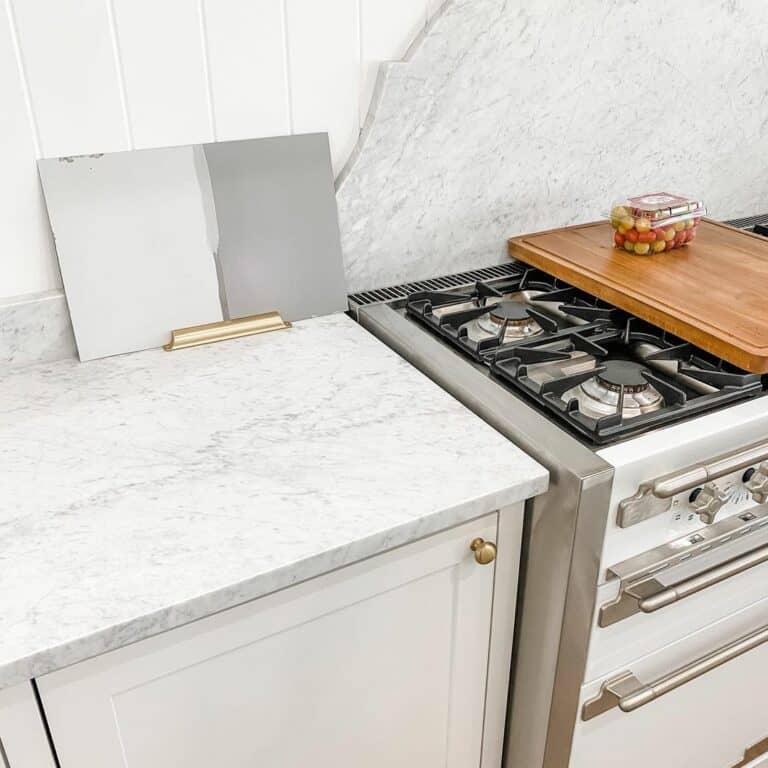 White Gas Range With Gray Marble Backsplash