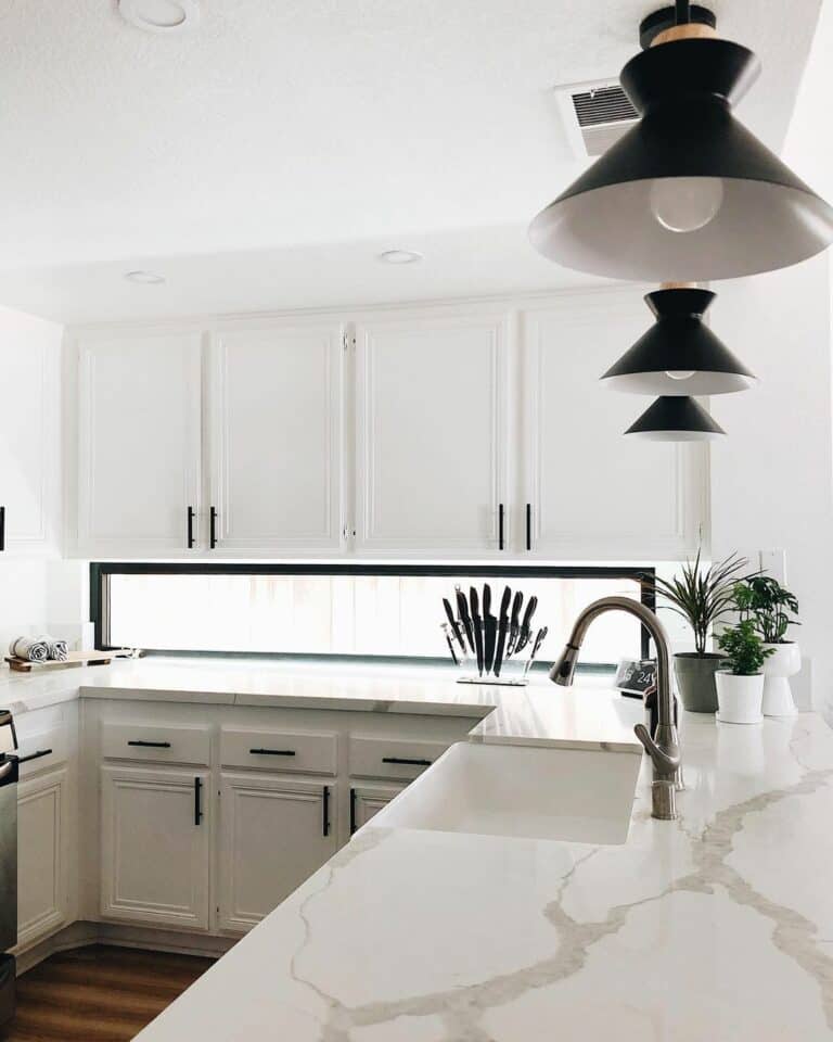 All White Kitchen With Black Island Lighting