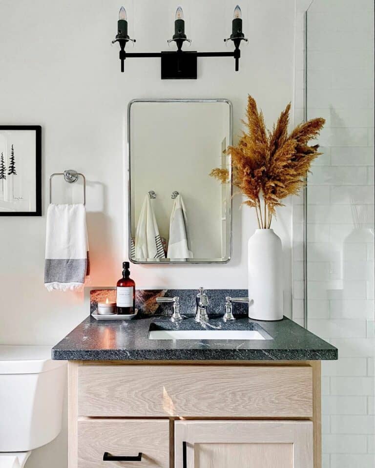 Organized Bathroom With Black Marble and Natural Wood Vanity