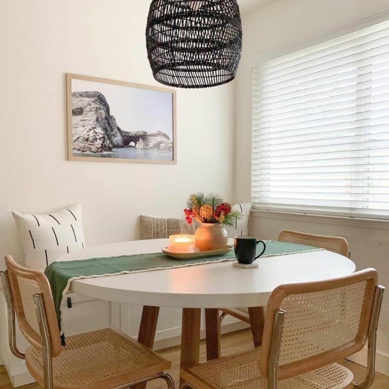 Small Dining Nook With Black Rattan Light Fixture