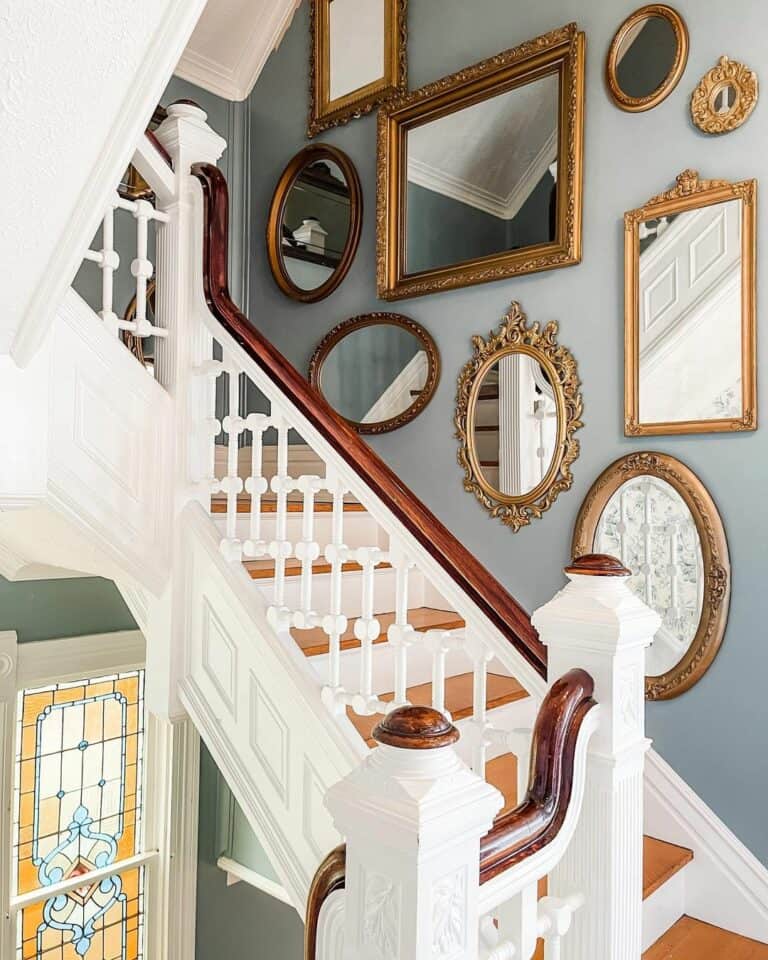 Two-toned Staircase With Gold Mirror Gallery Wall