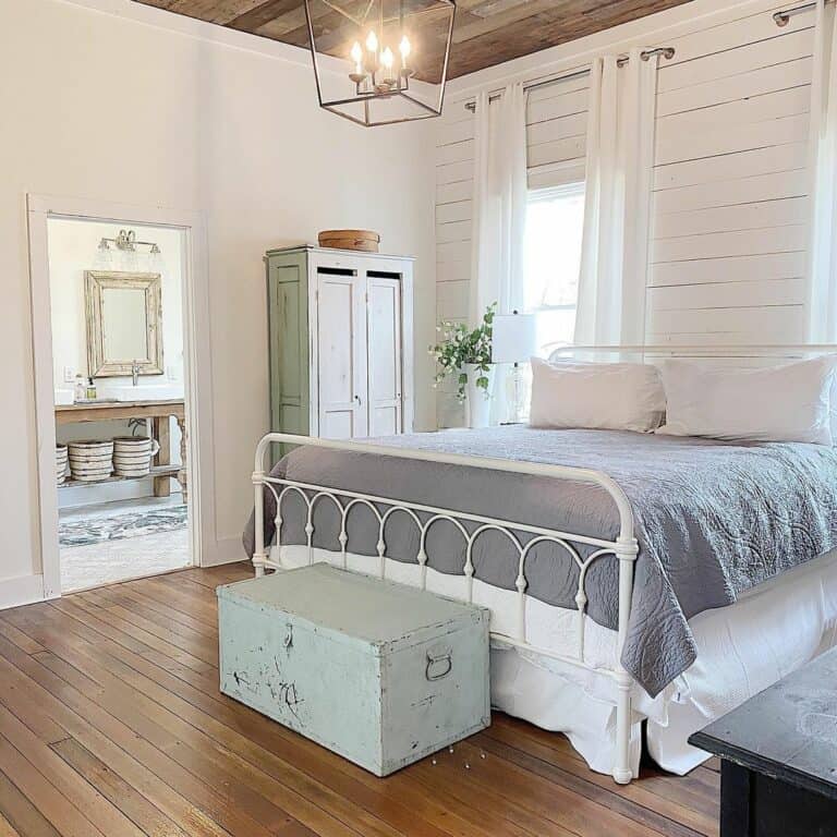 White Metal Bed in Farmhouse Bedroom With Ensuite Bathroom