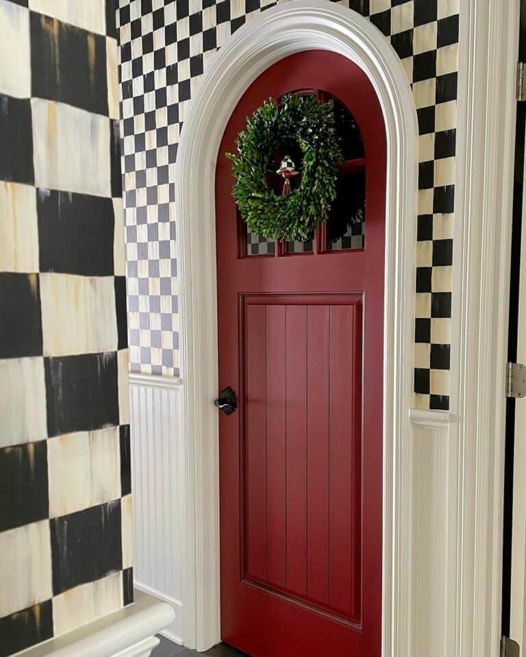 Checkered Walls Surround a Red Arched Door