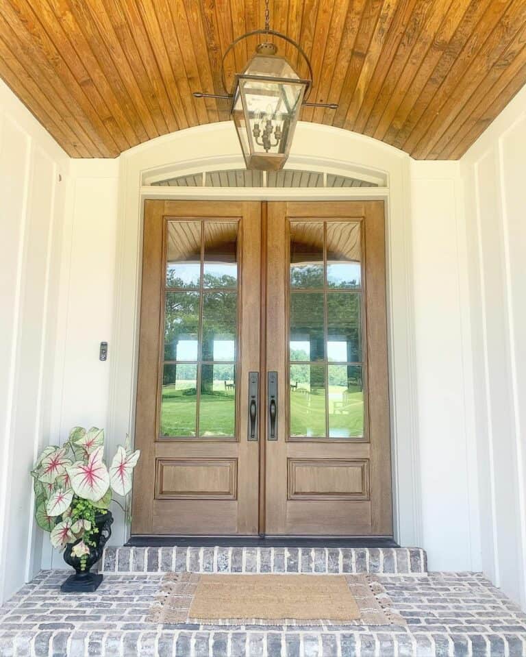 Rustic Brick Porch With Wooden Front Door