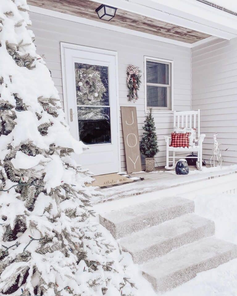 Snowy Porch With Wooden Christmas Welcome Sign