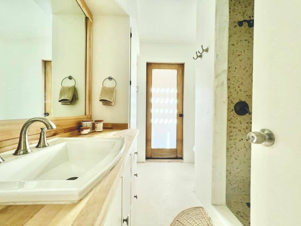 White Bathroom With Wood-framed Door