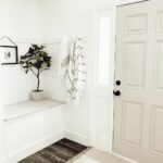White Entryway With Dark Natural Wood Flooring