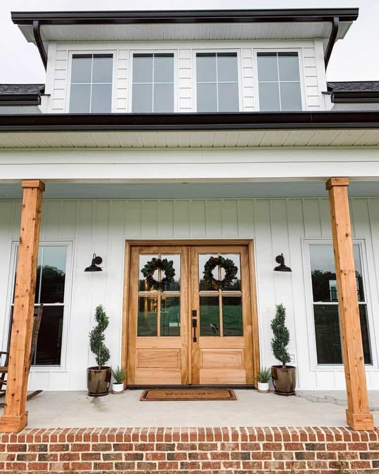 White Farmhouse Porch With Wooden Doors
